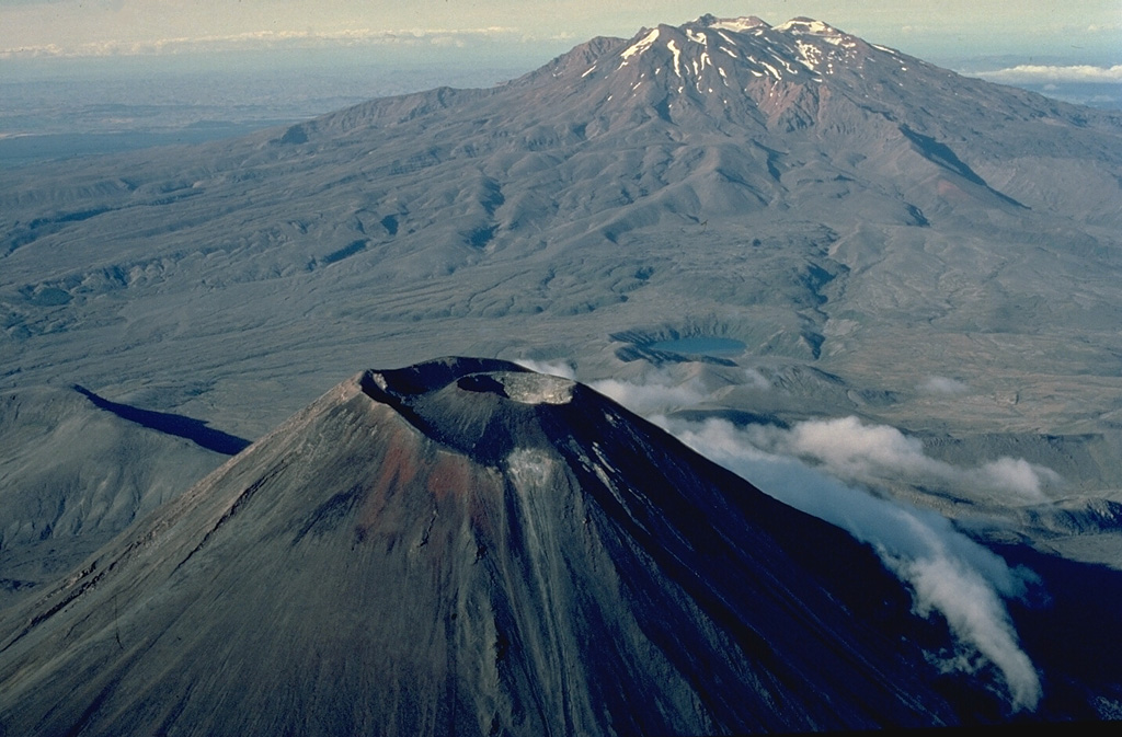 Two New Zealand volcanoes, the symmetrical Ngauruhoe in the foreground and the massive Ruapehu in the background, are stratovolcanoes with dramatically different profiles.  The steep-sided cone of Ngauruhoe was formed during the past 2500 years by repeated eruptions from a single central conduit.  The broad, elongated Ruapehu is a complex volcano that was formed by eruptions over a much longer period of time that constructed at least four overlapping volcanic edifices. Copyrighted photo by Katia and Maurice Krafft, 1986.