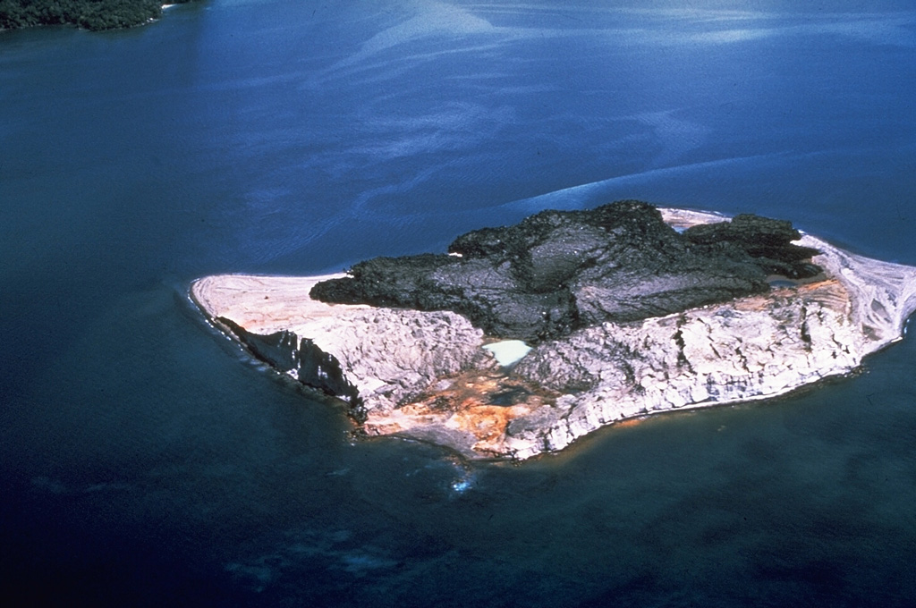The St. Andrew Strait volcano is located in the Admiralty Islands north of Papua New Guinea. The volcanic complex consists of a series of overlapping Quaternary cones formed by rhyolitic lava flows and pyroclastic deposits on Lou and Tuluman Islands. Volcanism is aligned along a curved arc, extending through the 12-km-long Lou Island. Tuluman Island, seen here from the SW with Lou Island 1.5 km away at the upper left, was formed during a 1953-57 eruption. Photo by Wally Johnson, 1964 (Australia Bureau of Mineral Resources).