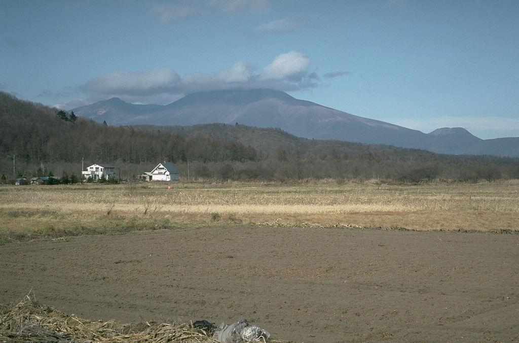 Asamayama is seen in here from the SE. The summit cone of Maekakeyama was constructed within an east-facing collapse scarp from the failure of Kurofuyama, whose rim forms the peak to the left of Maekakeyama. Ko-Asamayama is a flank lava dome that visible on the lower-right horizon. Photo by Tom Simkin, 1993 (Smithsonian Institution).