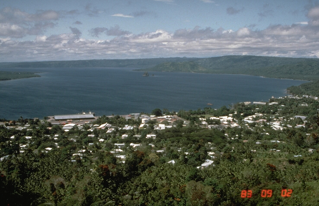 Simpson harbor, seen here from Rabaul Volcano Observatory overlooking the city of Rabaul in 1983, fills the NW part of 8 x 14 km Rabaul caldera. Matupit Island appears at the left margin of the photo, and Vulcan, the site of major eruptions in 1937 and 1994, is the low cone across the harbor at the right-center. Photo by Norm Banks, 1983 (U.S. Geological Survey).