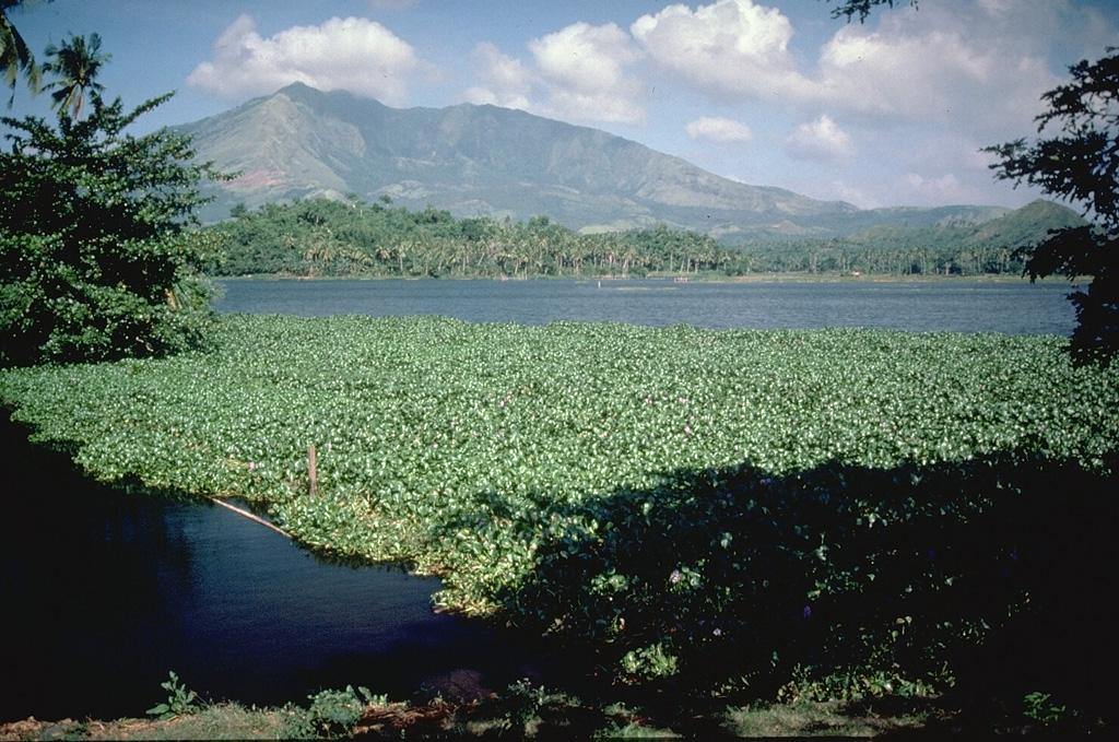 Mount Iriga has a horseshoe-shaped crater opening to the SE that resulted from a large flank collapse during a Holocene eruption. The hummocky terrain in the foreground encloses small ponds on the surface of the debris avalanche deposit. Photo by Chris Newhall (U.S. Geological Survey).