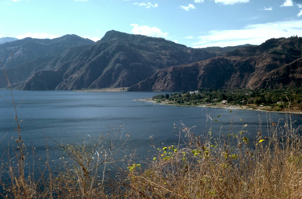 The resort town of Panajachel occupies a delta of the river of the same name that flows into Lake Atitlán, within the Atitlan caldera. The northern caldera wall rises about 1 km above the lake surface. The level of the lake has fluctuated more than 10 m over periods of several decades, and titles exist to land now submerged hundreds of meters from the current shoreline. High heat flow is present in the lake. Photo by Lee Siebert, 1988 (Smithsonian Institution).