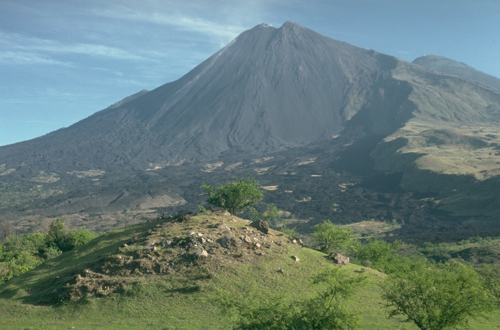 MacKenney cone, the historically active vent of Pacaya volcano in Guatemala, was constructed within a horseshoe-shaped crater produced by collapse of the summit of an ancestral volcano about 1,100 years ago. The SW crater rim forms the steep-sided scarp at the right. The blocky hill in the foreground is a hummock from the debris avalanche produced by the collapse. The avalanche extended for 25 km. Photo by Lee Siebert, 1988 (Smithsonian Institution).