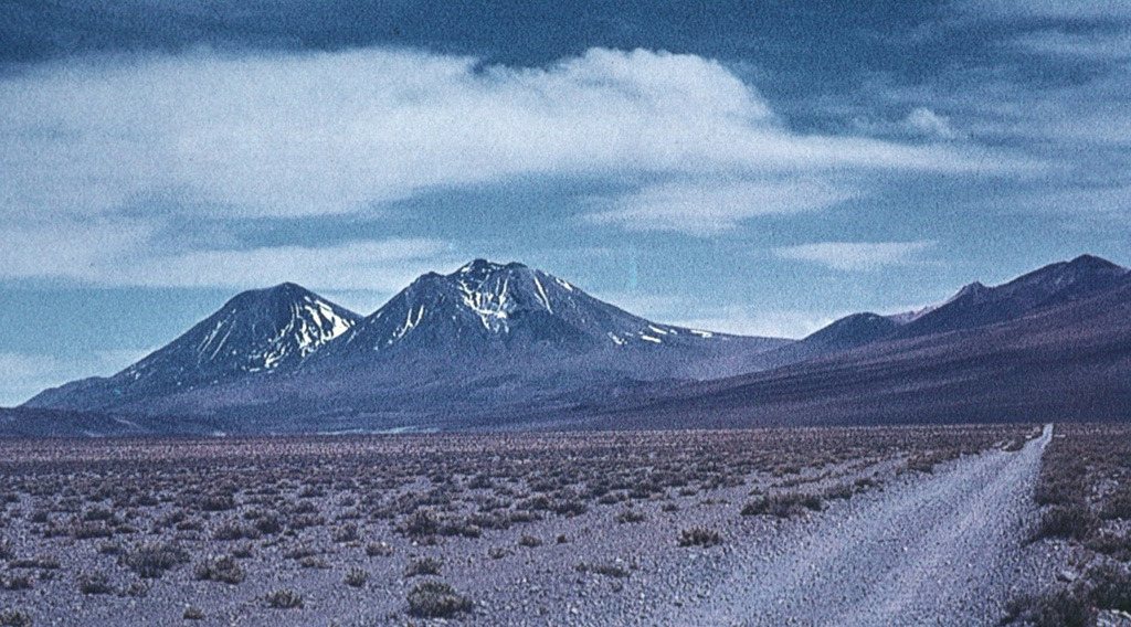 The composite volcano of San Pedro in the arid Atacama desert of northern Chile is one of the world's highest historically active volcanoes.  The 6145-m-high San Pedro (left) is located to the west of its older twin volcano, 6092-m-high San Pablo (center).  The youngest cone of San Pedro was constructed within the horseshoe-shaped crater left by the collapse of an older edifice, which produced a large debris avalanche to the west.  Reports of variable reliability mention historical eruptions in the 19th and 20th centuries. Photo by Oscar González-Ferrán (University of Chile).