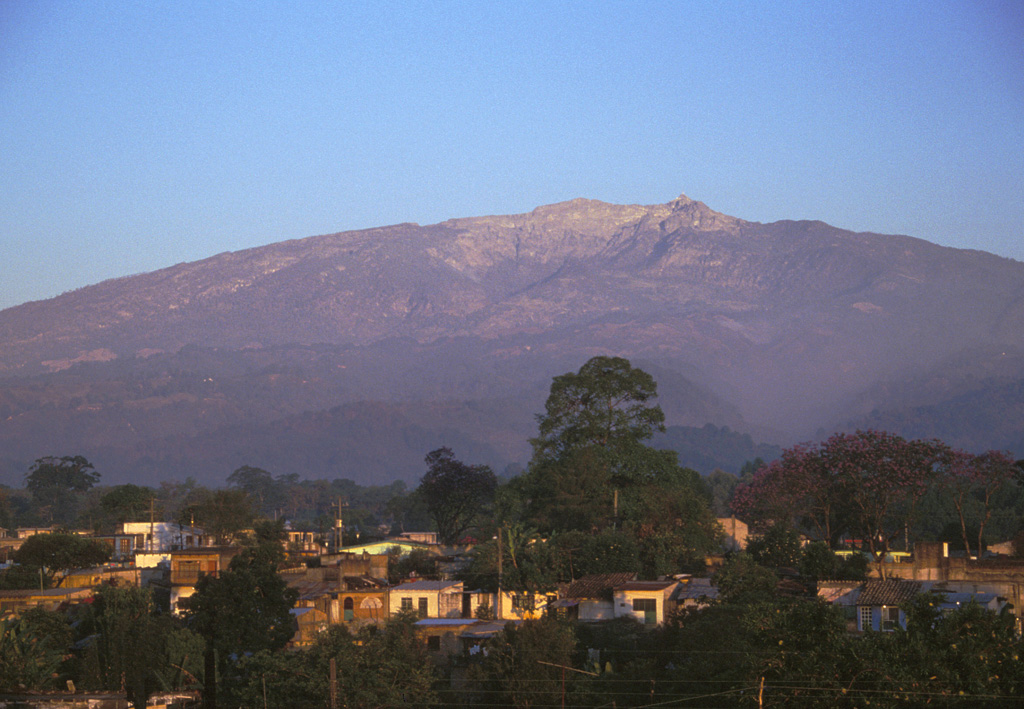 Large compound horseshoe-shaped scarps, formed in part by edifice collapse, are visible near the summit of the eastern side of Cofre de Perote volcano. The massive size of the edifice can be appreciated in this photo taken from the city of Coatepec, which lies 21 km ESE and 3,000 m below the summit. Photo by Lee Siebert, 1999 (Smithsonian Institution).