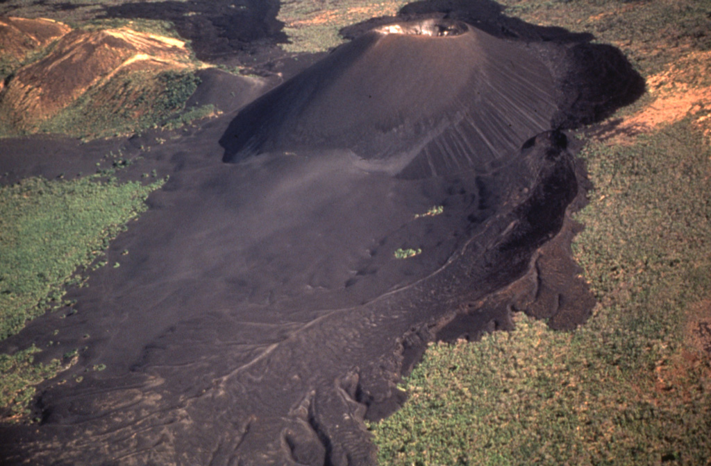 An aerial view from the SW after the 1992 eruption shows the greatly enlarged summit crater.  The 1992 eruption expanded the summit crater to 370 m in diameter and an average depth of 90 m.  Heavy ashfall caused extensive damage to buildings and croplands.  No lava flows were erupted.  The lobate lava flow extending to the bottom of the photo was erupted in 1968, and the tephra-mantled flow to its left was emplaced in 1960. Photo by Jaime Incer, 1992.