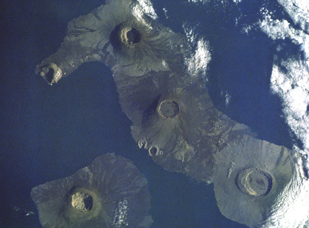 This dramatic Space Shuttle photo from a 1988 mission shows five major calderas of the Galápagos Islands.  Caldera diameters capping these basasltic shield volcanoes range up to 8 km.  At the lower left is Fernandina volcano.  At the lower right is mostly vegetated Alcedo volcano on Isabela Island.  Above and to the left is Darwin volcano, with the two prominent breached tuff cones, Tagus and Beagle, on its SW flank.  Volcán Wolf is at the top of the photo, and Volcán Ecuador with its breached caldera forms the NW tip of Isabela Island. NASA Space Shuttle image, 1988 (http://eol.jsc.nasa.gov/).
