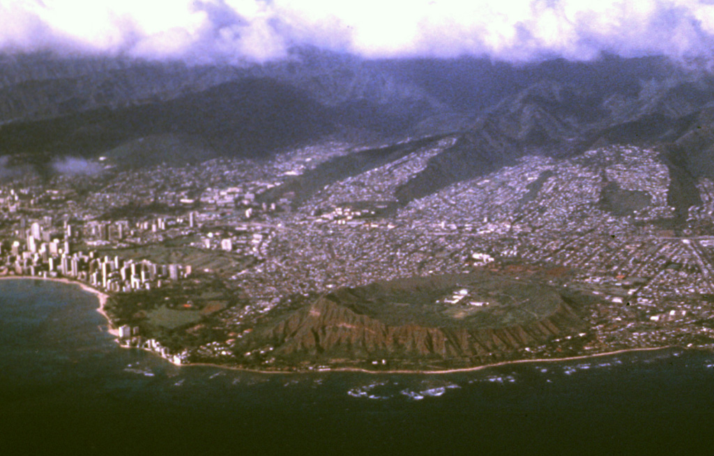 The city of Honolulu drapes the lower flanks of the massive Koolau shield volcano on the island of Oahu.  Most of Koolau volcano is of Pliocene-to-Pleistocene age, but a series of late-Pleistocene to perhaps early Holocene explosive eruptions formed a chain of tuff cones, cinder cones, and spatter cones at the SE end of the island.  The largest of these is the Diamond Head tuff cone (lower right), which forms a dramatic backdrop to the city of Honolulu.  Photo by Jeff Plaut, 1990 (Jet Propulsion Laboratory, courtesy of Richard Fiske, Smithsonian Institution).
