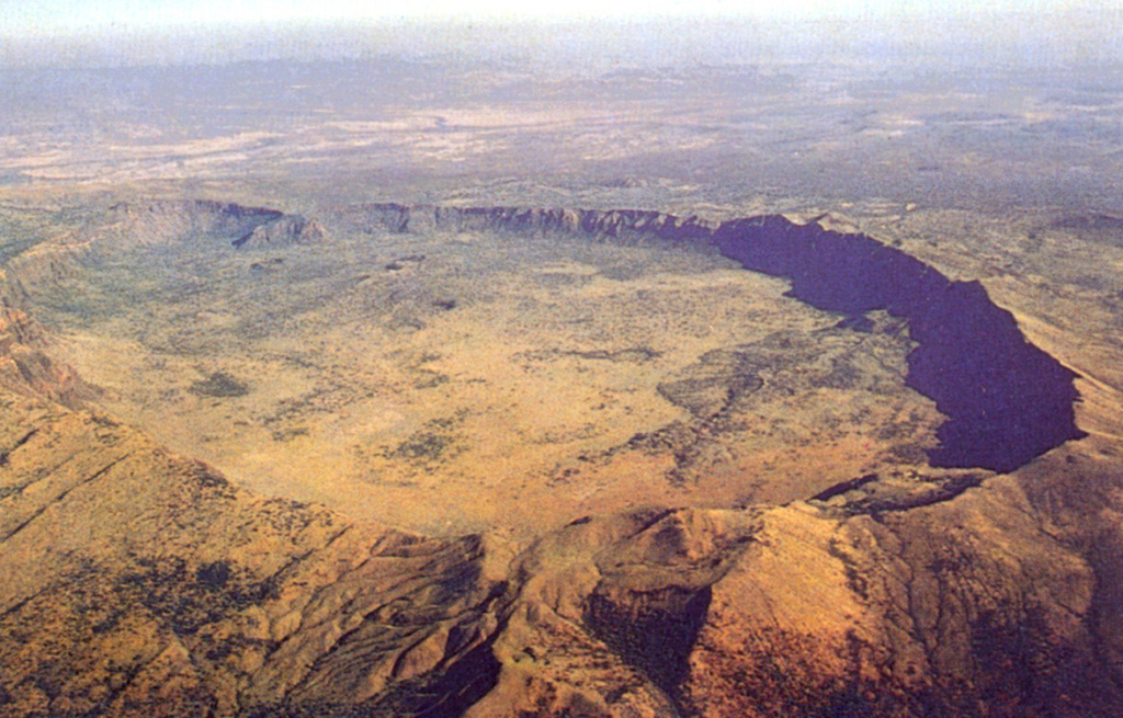 The impressive 5 x 8 km summit caldera of Silali volcano is seen in an aerial view from the SE. Formation of the 300-m-deep caldera is related to the incremental eruption of basaltic and trachytic lava flows about 63,000 years ago. N-S-trending rift valley faults cutting across the volcano can be seen at the lower left. Some of cones on the caldera floor and flanks may be little more than a few hundred years old. Photo by Martin Smith, 1993 (copyright British Geological Survey, NERC).