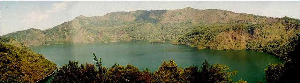 Lake-filled Ngozi caldera is seen here from its southern rim. The 1.5 x 2.5 km caldera lake is bounded by steep-walled cliffs 150-300 m high. The caldera is the most prominent volcanic feature of the Poroto Ridge, a transverse structure at the northern end of the Karonga basin in SW Tanzania. Numerous cones are situated along the ridge. The youngest activity along the ridge appears to have originated from Ngozi caldera and from pyroclastic cones to the N. Photo by David Williamson, CNRS, France.