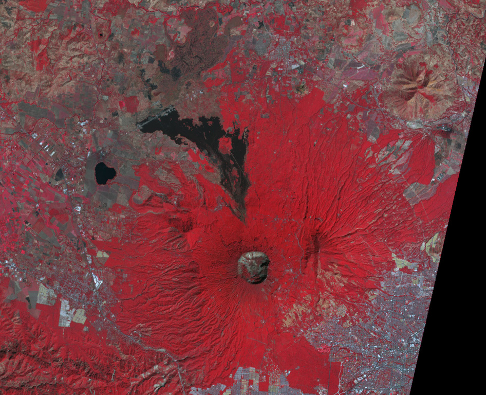 This false-color NASA ASTER image (N is at the top) looks down on the 1.5-km-wide San Salvador summit crater. The  lava flow to the north was erupted from a flank vent in 1917; the small cone in the center of the summit crater also formed that year. Lake-filled Laguna de Chanmico maar lies on the lower NW flank (left-center). The capital city of San Salvador is at the lower right. NASA ASTER image, 2001 (https://earthobservatory.nasa.gov/).