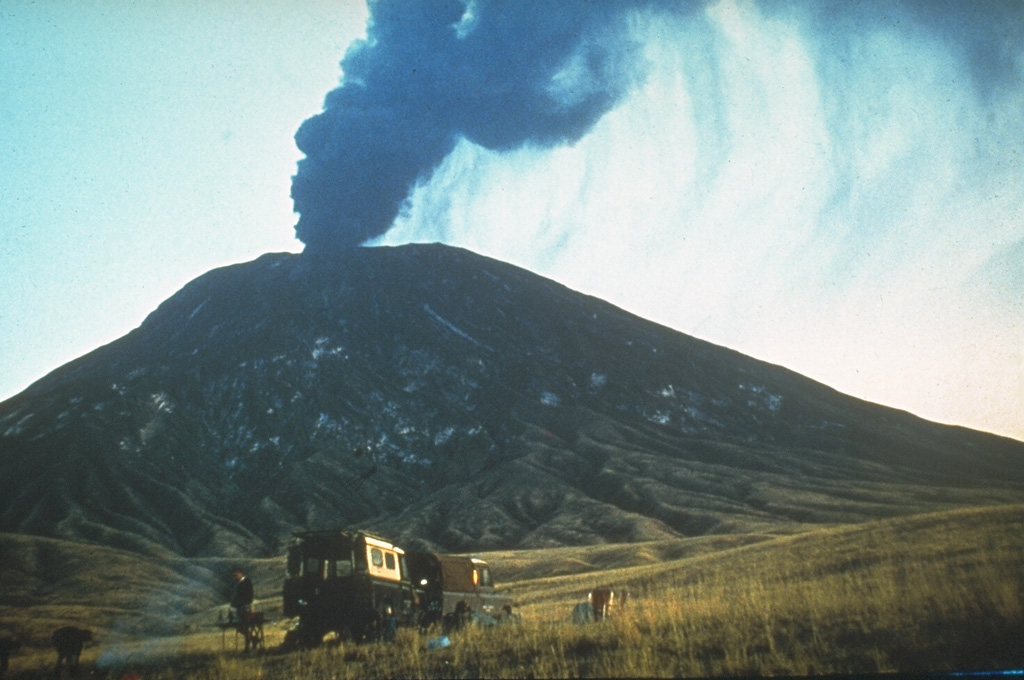 An ash plume rises above the summit of Ol Doinyo Lengai in 1966, near the end of an eruption that began in 1960. Quiet extrusion of carbonatite lava apparently took place from 1960 to 1966, although few direct observations were made. In early August 1966 activity changed to vigorous ash eruptions. A powerful explosive eruption was observed on 22 August. Explosive activity was also reported on 28 October and the volcano was reported to be quiescent in late December 1966. Photo by Gordon Davies, 1966 (courtesy of Celia Nyamweru, Kenyatta University).