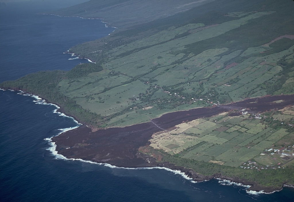 A black lava flow, one of only six erupted in historical time from vents outside the caldera of Piton de la Fournaise, reached the sea in April 1977, forming a new lava delta.  Following minor lava ejection that began on March 24-25 SE of Dolomieu crater, lava effusion began April 5-7 from several vents on the NE flank.  The resulting lava flows, active until April 16, burned sugar cane fields and destroyed houses in the town of Piton Ste Rose before reaching the sea below the town. Copyrighted photo by Katia and Maurice Krafft, 1977.