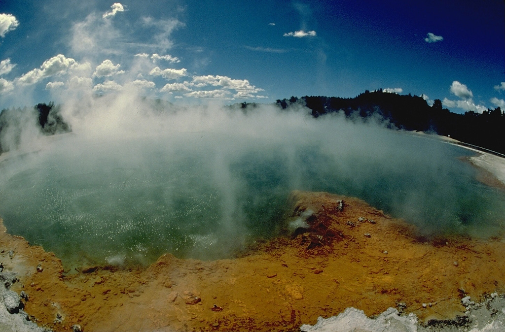 Steaming Champagne Pool is one of many thermal features of the 10-km-wide Reporoa caldera.  The caldera was formed about 230,000 years ago during the eruption of the Kaingaroa ignimbrite.  No eruptions have occurred since the Pleistocene in the caldera, but hydrothermal explosions took place in the Waiotapu thermal field north of the caldera at the time of the Kaharoa eruption of the Okataina volcanic centre about 800 years ago.  The Broadlands (Ohaki) hydrothermal field is located south of the poorly defined caldera margin. Copyrighted photo by Katia and Maurice Krafft, 1986.