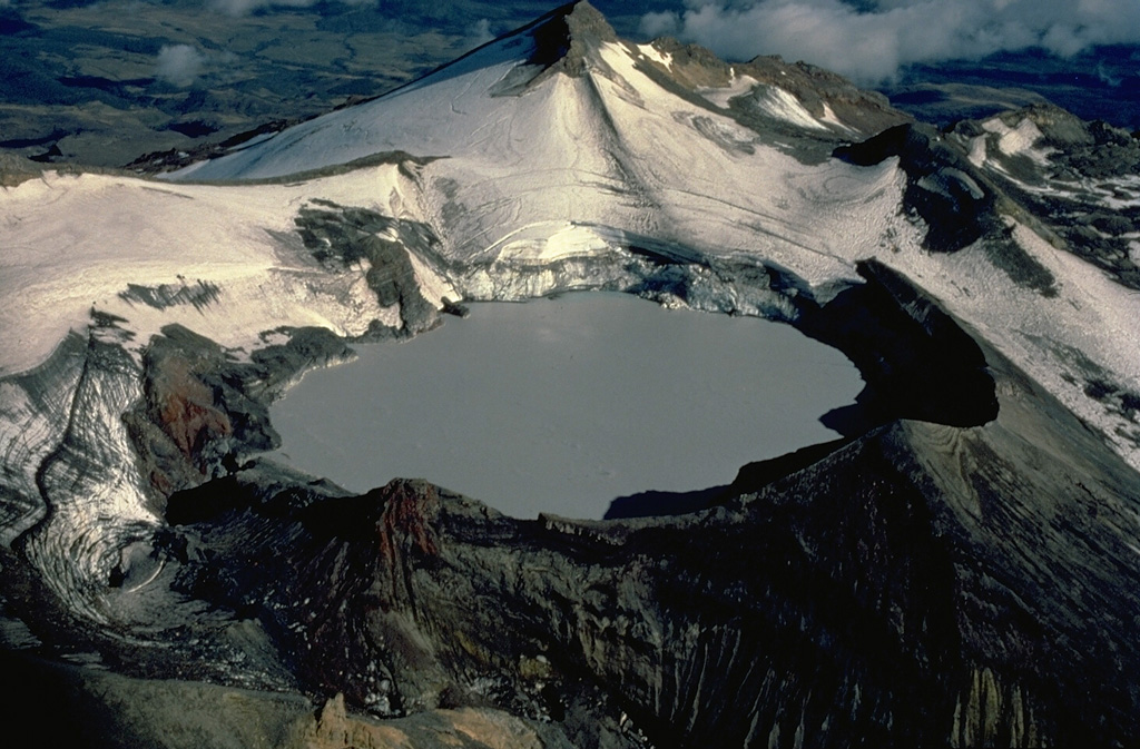 Appropriately named Crater Lake, the historically active summit vent of New Zealand's Ruapehu volcano, is one of the world's most frequently active crater lakes.  Nearly 50 explosive eruptions originating from a vent beneath the lake have been recorded during the 20th century.  This view from the NW shows the 600-m-wide lake with glacier-clad Mitre Peak in the background. Copyrighted photo by Katia and Maurice Krafft, 1986.