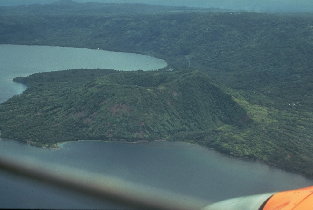 The largest historical Rabaul eruption took place from 29 May to 2 June 1937 from two vents on opposite sides of the caldera, Vulcan and Tavurvur. Present-day Vulcan, seen here from the NE, was built up from sea level to a height of 243 m during four days of powerful explosive eruptions that ended the evening of 2 June. About 500 people were killed by pyroclastic flows and heavy ashfall. Rabaul city was buried by ash and pumice, and a tsunami swept ships onto the shore. Tavurvur was active for less than one day. Photo by Russell Blong, 1980 (Macquarie University).