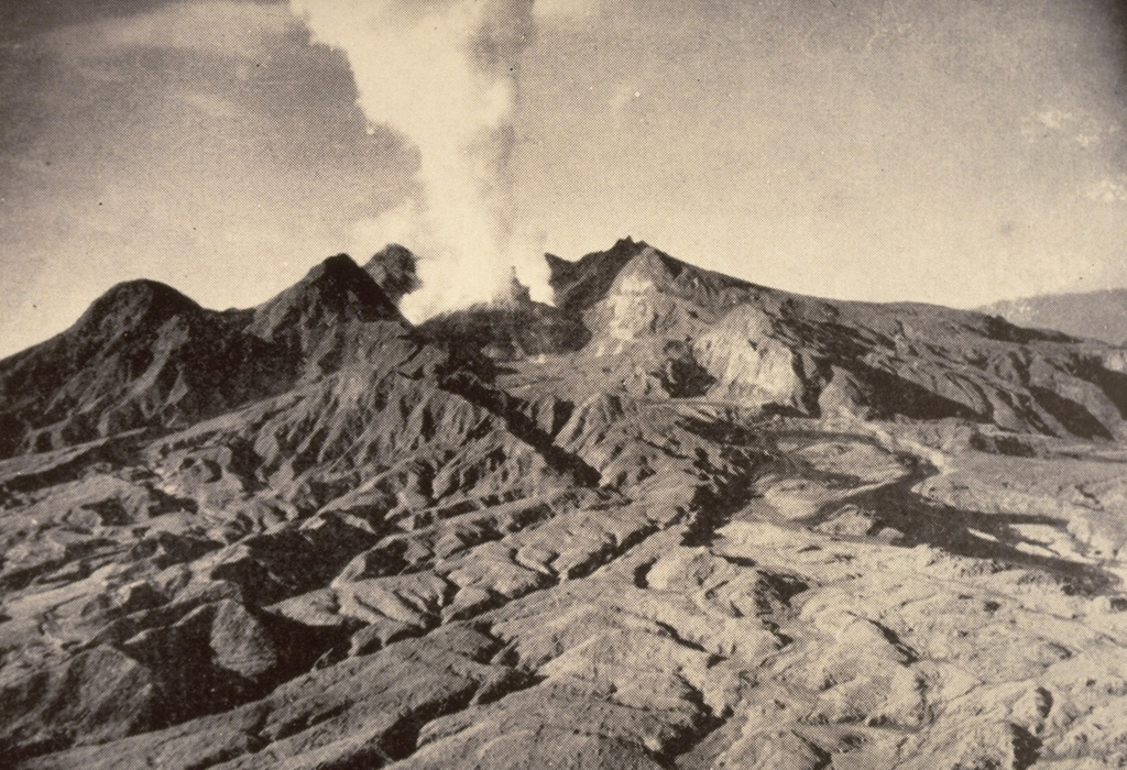 The first historical eruption of Lamington was in 1951, prior to which it was not known to be a volcano by those living on its flanks. Following continuous light ash emission beginning on 17 January the paroxysmal eruption on 21 January produced pyroclastic flows and surges that swept all sides of the volcano to a maximum distance of 12 km to the north, killing nearly 3,000 people. This 5 February photo shows the devastated northern flanks and a plume rising from a growing lava dome in the new crater. Slow dome growth ended in 1956. Photo by Tony Taylor, 1951 (Australia Bureau of Mineral Resources).