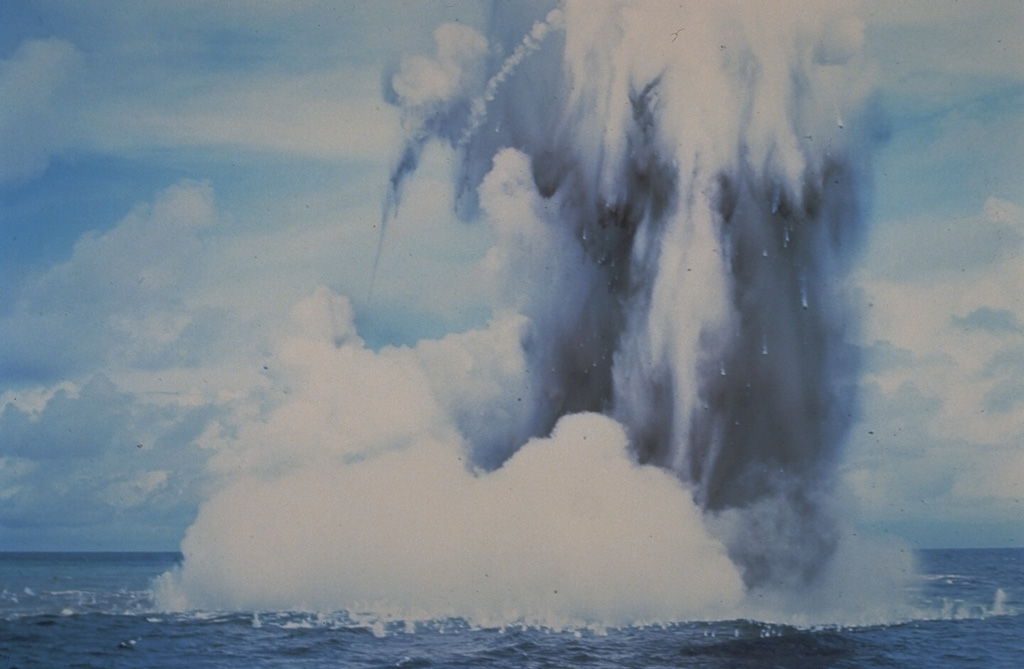 Submarine explosions from Kavachi volcano eject a cock’s-tail plume of water, steam, and ash above the sea surface in July 1977. Large ejected blocks are visible falling from the plume and impacting the sea surface. Similar activity was observed over a period of less than a week. Photo by W.G. Muller, 1978 (Barrier Reef Cruises, Queensland, Australia; courtesy of D. Tuni).