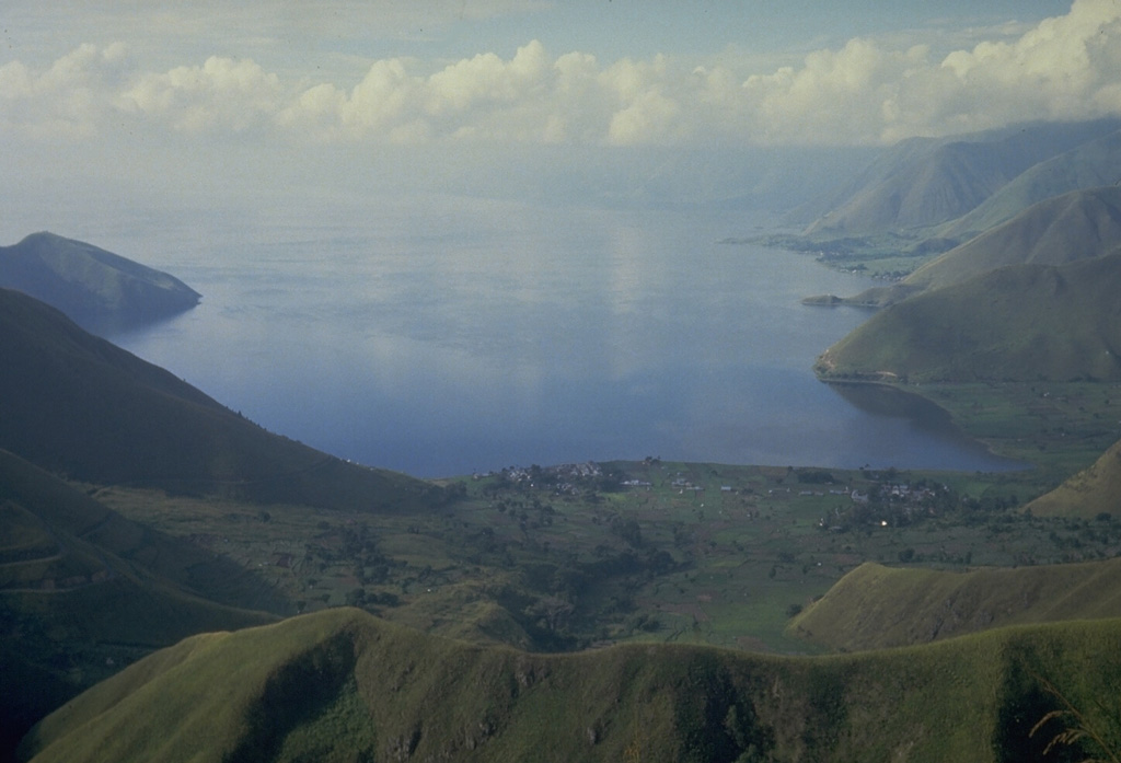 Lake Toba, the largest lake in SE Asia, fills more than half of the 35 x 100 km Toba caldera, the Earth's largest Quaternary caldera. The caldera walls rise steeply 400-1,200 m above the 1,700 km2 lake, which is one of the world's deepest with a maximum depth of 530 m. This view looks south from the northern caldera rim. Photo by Tom Casadevall, 1987 (U.S. Geological Survey).