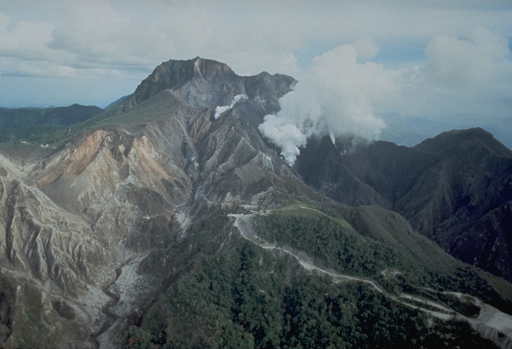 An aerial view of the north flank of Pinatubo shows the area devastated by explosions on 2 April 1991. This eruption was the first in a progressively intensifying series of eruptions that led to caldera formation on 15 June. The road in the foreground provided access to a geothermal drill station. Photo by Chris Newhall, 1991 (U.S. Geological Survey).