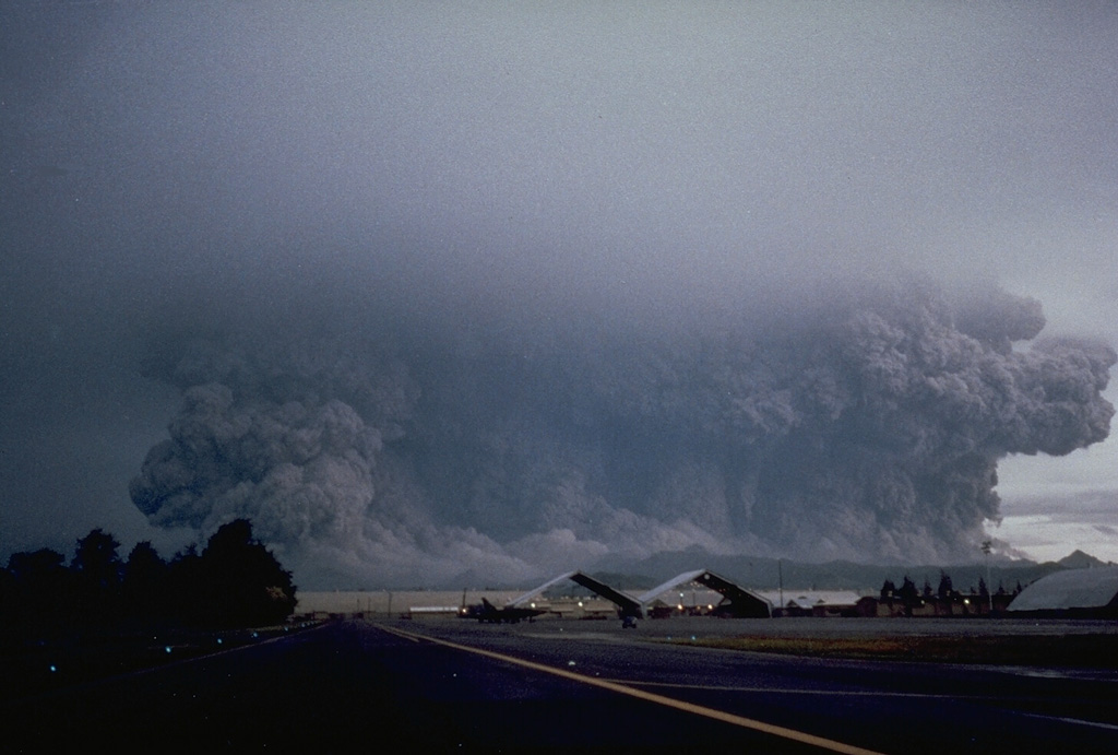 A powerful eruption of Pinatubo that began at 0555 on 15 June 1991 viewed from Clark Air Base ENE of the volcano. The broad ash column, which appears to be as wide as the volcano, is a result of pyroclastic flows that are sweeping radially down the volcano's flanks. Eruptions producing pyroclastic flows began on 12 June and continued intermittently until the climactic eruption that began at 1342 on the 15th and resulted in caldera collapse during sustained eruptions that lasted more than 6 hours. Photo by Robert LaPointe, 1991 (U.S. Air Force).