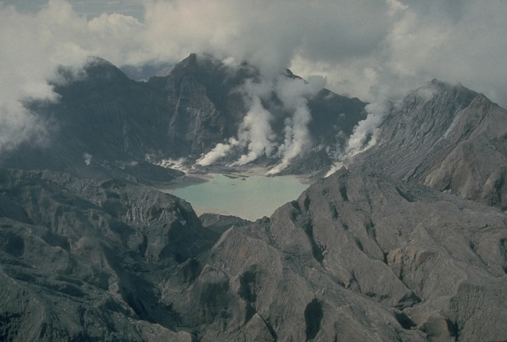 The major explosive eruption on 15 June 1991 created a 2.5-km-wide caldera at the summit of Pinatubo. The elevation of the caldera floor is more than 900 m below that of the pre-eruption summit. Plumes rise from fumaroles on the caldera floor in this 4 October 1991 photo taken from the N. The outer flanks of the caldera are stripped of vegetation and covered with ash and pyroclastic surge deposits. Photo by Chris Newhall, 1991 (U.S. Geological Survey).