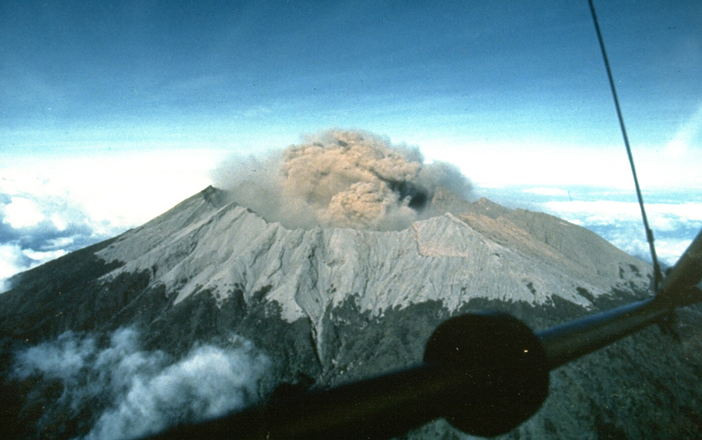Raung volcano, near the eastern tip of Java, contains a 2-km-wide summit caldera. One of Java's most active volcanoes, Raung produces frequent moderate explosive eruptions, like this one in 1988 from a cone within the caldera, that keep the upper flanks of the volcano sparsely vegetated. Raung forms part of a NW-SE-trending chain of volcanoes constructed near the SW rim of Ijen caldera. Photo by Willem Rohi, 1988 (Volcanological Survey of Indonesia).
