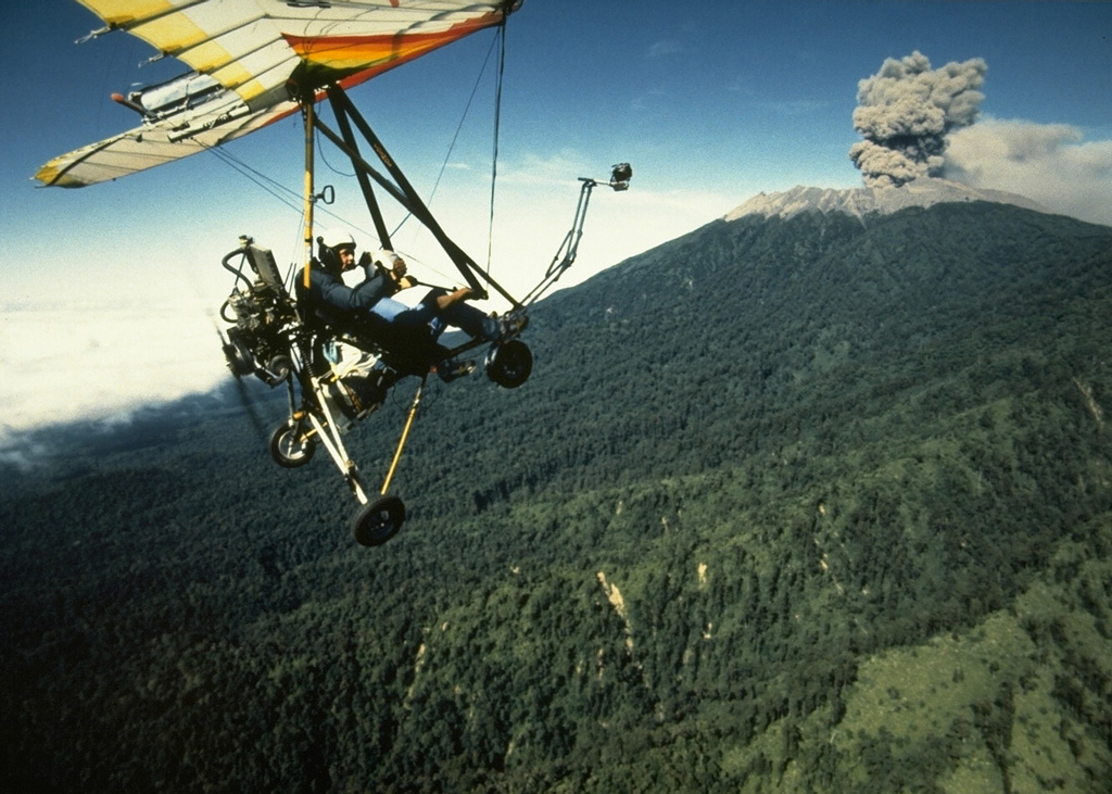 An ultralight aircraft was used by scientists from France and the Volcanological Survey of Indonesia to monitor activity at Raung in 1988. This July view shows an ash plume rising above the forested northern flank of Raung volcano. Hundreds of explosive eruptions were recorded during August and September 1988. This eruption began in 1987 and continued into 1989. Photo by Willem Rohi, 1988 (Volcanological Survey of Indonesia).