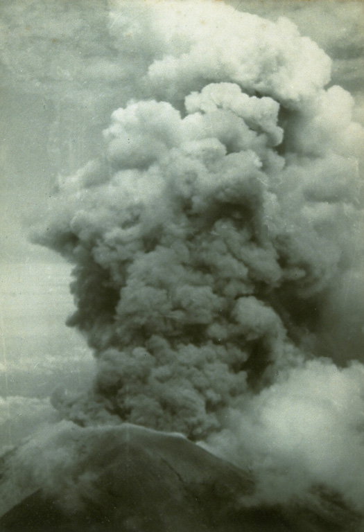 An ash plume rises above the summit crater of Agung volcano on 17 March 1963 during the first of two powerful explosive eruptions that caused much devastation to the island of Bali. The eruption began on 19 February with a lava flow that traveled down the N flank. Major explosive events occurred on 17 March and 16 May that produced devastating pyroclastic flows and lahars that killed more than 1,100 people. Photo by Djazuli, 1963 (Volcanological Survey of Indonesia).