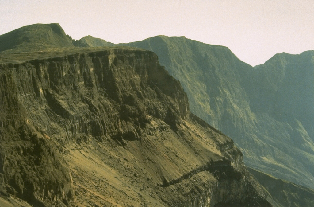 Tambora's serrated NE caldera rim towers 1,250 m above the caldera floor. The 6-km-wide caldera was formed in 1815, during one of the world's most powerful eruptions of the past 10,000 years. Since 1815 only a few minor eruptions have occurred on the caldera floor. Photo by Rizal Dasoeki, 1986 (Volcanological Survey of Indonesia).