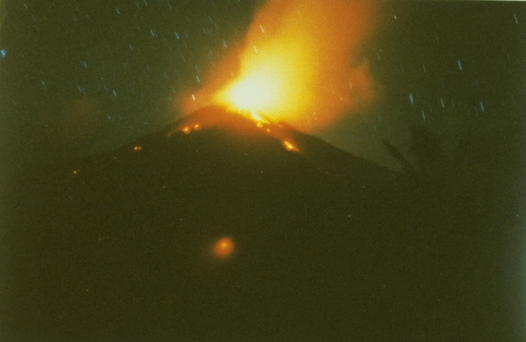 A time exposure captures a nighttime view from the south of explosive eruptions at the summit of Karangetang volcano in February 1985, part of an eruption that began in May 1983 and lasted until the end of 1988.  On February 24, 1985, a new vent opened on the south flank, sending a lava flow down the Batuawang River. Photo by S.R. Wittiri, 1985 (Volcanological Survey of Indonesia).