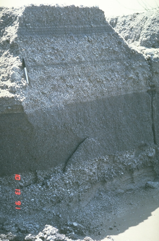These relatively fine-grained layers are lahar deposits produced by successive overflows of dikes along the Bambam River, about 35 km NE of Pinatubo volcano in the Philippines. The photo was taken on 13 October 1991, a little more than a month after the end of the devastating 1991 eruption. Note the pen at the upper left for scale. By the end of 1991, rainfall-induced lahars had traveled 50 km down the Bambam River. Photo by Chris Newhall, 1991 (U.S. Geological Survey).