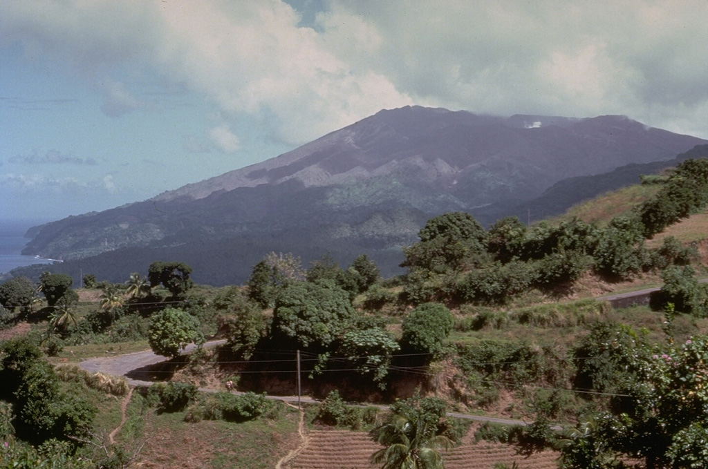 Soufrière volcano, seen here from the south, forms the northern end of the island of St. Vincent.  Its broad, flat summit is formed by several generations of craters.  The present-day, 1.6-km-wide crater, cut on its NE side by a smaller crater formed in 1812, has been the site of lava dome formation and explosive removal on several occasions since the first historical eruption in 1718.  Pyroclastic flows from eruptions in 1812, 1902, and 1979 reached the coast. Photo by Richard Fiske, 1980 (Smithsonian Institution).