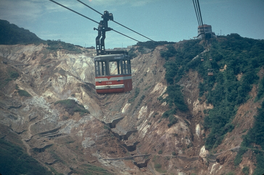 Aerial cable cars stretching across Owakudani provide a view of one of the many thermal areas in Hakone caldera. Hot spring resorts surround a complex of lava domes in the center of the caldera. Photo by Lee Siebert, 1963 (Smithsonian Institution).