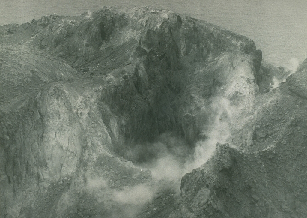 On 27 November 1976 a plume, water discoloration, and sulfur odor were reported from Matthew Island. It was later noted that no noticeable eruptive event or change in island morphology had occurred since 1958. This February 1977 photo shows the steaming crater of Matthew Island volcano. Photo by Royal New Zealand Air Force, 1977.
