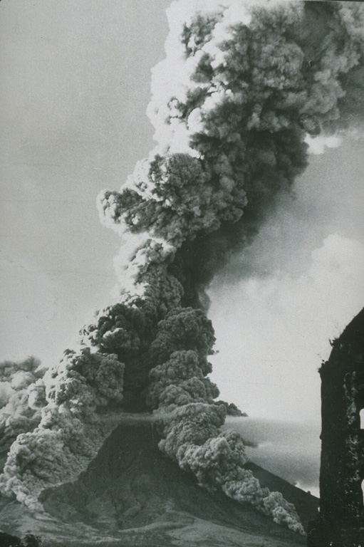 As ash plume rises above the summit of Mayon volcano on 27 April 1968 as pyroclastic flows travel down the SW and S flanks. This view from the SSW flank shows the Camalig church to the right, which was damaged by pyroclastic flows during the 1814 eruption. The 1968 eruption began on 21 April and lasted until 20 May. Photo courtesy of William Melson, Smithsonian Institution, 1968.
