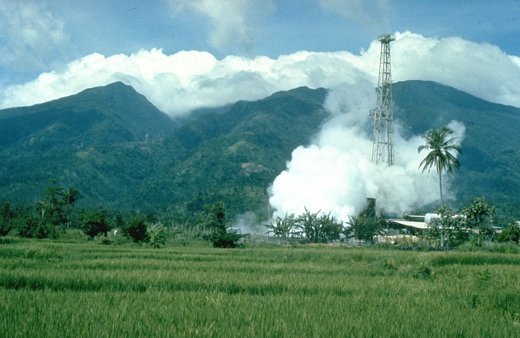 Malinao is forested with a summit crater that opens towards the east. The Tiwi geothermal field, seen here with the volcano in the background, is located on the E flank. The geothermal field is located near Luzon's largest fumarole field, which includes siliceous sinter deposits at Naglabong. Photo by Chris Newhall (U.S. Geological Survey).