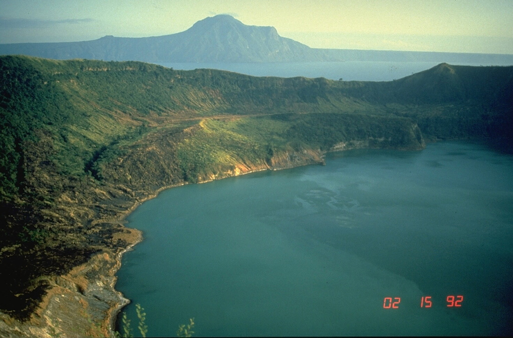 This view of Main Crater Lake in the 3-km-wide caldera on Volcano Island, looks across Lake Taal to the NE rim of the 15 x 20 km Taal caldera. The surface of the 267 km2 lake is only 3 m above sea level. Volcano Island has been the source of explosive eruptions with pyroclastic surges that devastated lakeshore areas. Pleistocene eruptions that formed the caldera greatly modified the topography of southern Luzon Island. Photo by Chris Newhall, 1989 (U.S. Geological Survey).