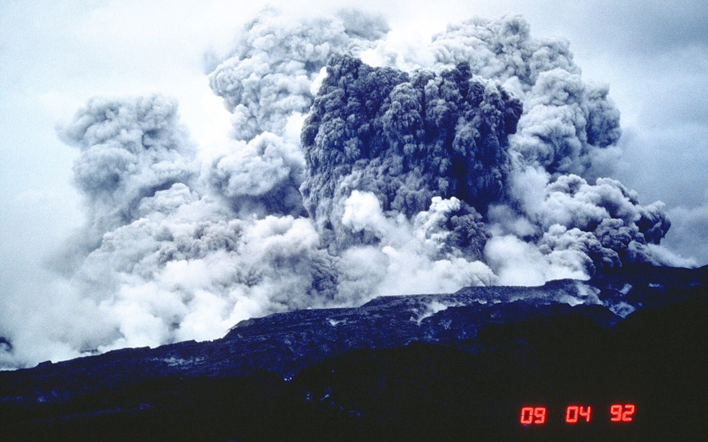 An ash plume rises several kilometers above the west flank of Pinatubo on 4 September 1992. This was not the result of an eruption, but of secondary explosions produced when water contacted still-hot pyroclastic flow deposits of the 1991 eruption. This can occur either when channel banks eroded into the deposits collapse into streams, or when groundwater invades hot deposits along buried stream channels. Ash plumes as high as 18 km were produced by these events, as well as pyroclastic flows. Photo by Chris Newhall, 1992 (U.S. Geological Survey).