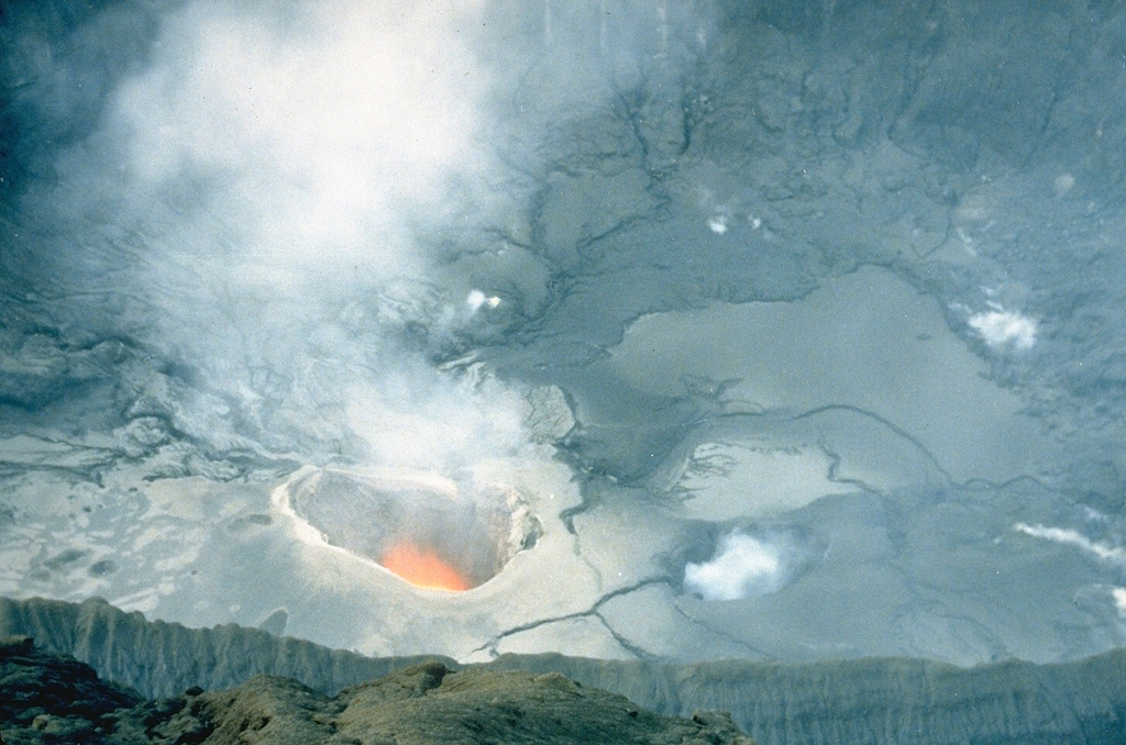 A plume rises from an incandescent vent on the floor of the crater of Nakadake on 25 April 1985. Moderate eruptions that ejected mud and ash had begun in April 1984 and continued intermittently until June 1985. Frequent ash eruptions occurred from 1 March to the night of 5-6 May 1985. Photo by Japan Meteorological Agency, 1985.