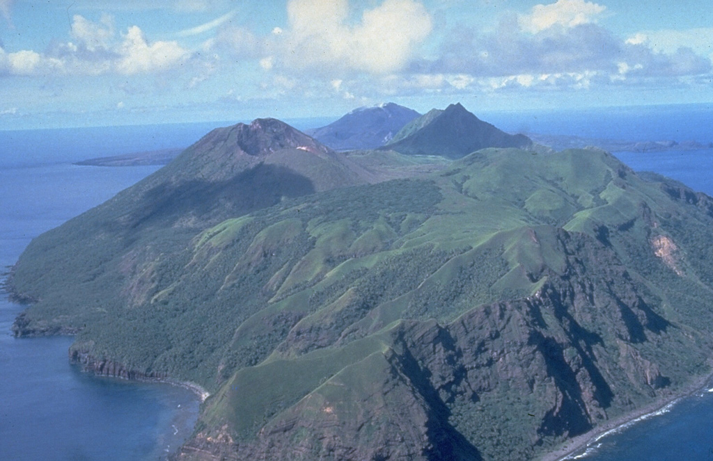 South Pagan volcano occupies the SW end of Pagan Island and has four craters. The ridge in the foreground is the eroded rim of a 4-km-wide caldera containing the cone. Eruptions occurred during the 19th century, and North Pagan at the far center on the NE tip of the island has been frequently active. Photo by U.S. Navy, 1981.