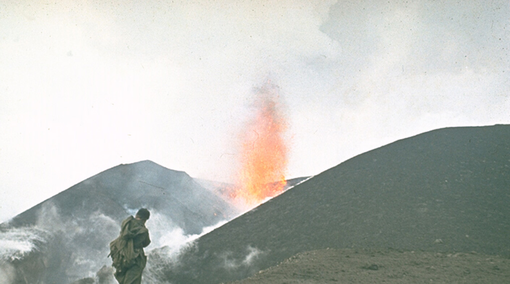 A volcanologist from the Institute of Volcanology in Petropavlovsk observes a lava fountain at an Alaid scoria cone in 1972. The eruption began on 18 June and lasted until 11 September. A chain of small cones formed on a 2-km-long fissure on the lower NW flank and lava flows reached the sea, forming a new peninsula. Photo by Yuri Doubik, 1972 (Institute of Volcanology, Petropavlovsk).