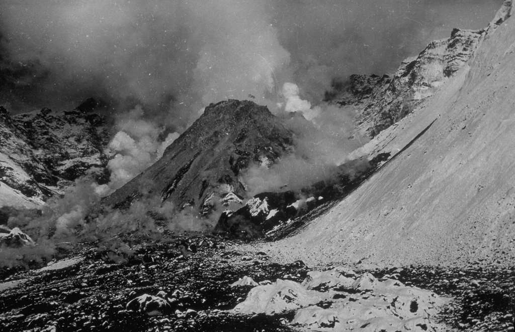 By the time of this 27 August 1956 photo, a new lava dome growing in the Bezymianny crater had reached a height of 320 m. The dome began growing in April, following a catastrophic eruption on 30 March in which the summit of the volcano collapsed, producing a massive debris avalanche and lateral blast towards the SE. The walls of the resulting horseshoe-shaped crater 1.3 x 2.8 km and 700 m deep that can be seen behind the lava dome. Gas emissions rise from the summit and base of the dome.  Photo by G.S. Gorshkov, 1956 (Institute of Volcanology, Petropavlovsk, published in Green and Short, 1971).