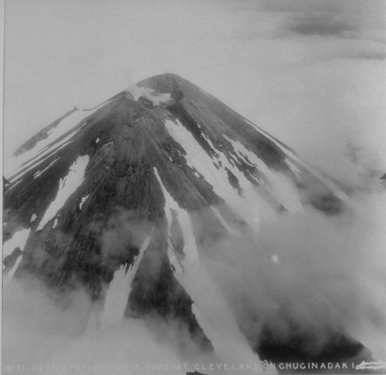 This aerial view of Mount Cleveland volcano from a generally eastward direction shows a small crater at the summit of the stratovolcano.  Cleveland is one of the most active volcanoes of the Aleutian arc. From the collection of Maurice and Katia Krafft.