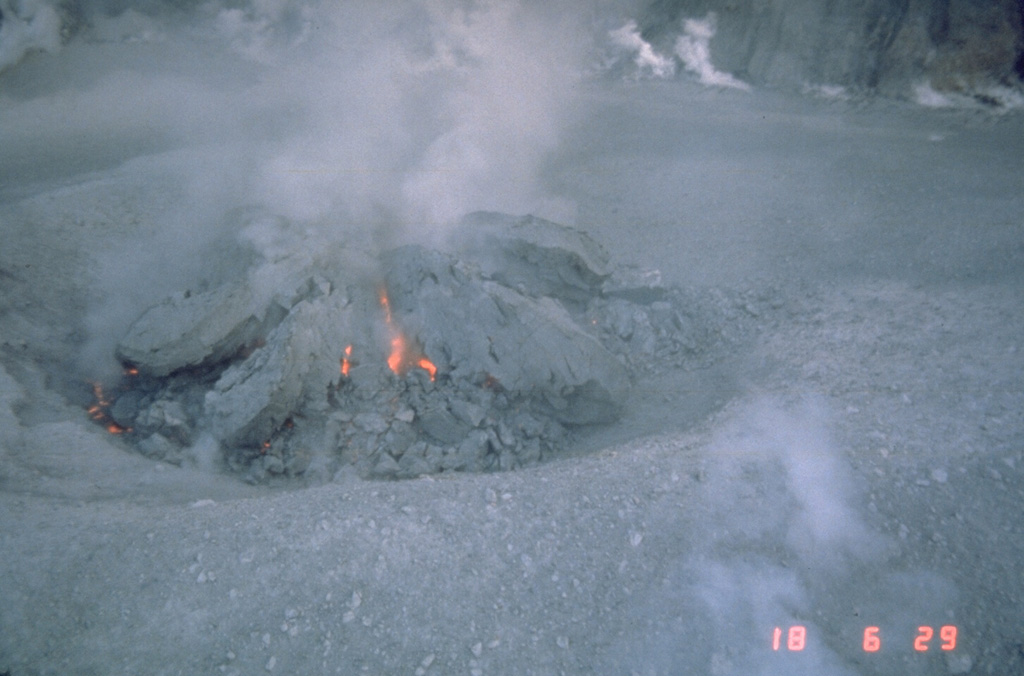 Incandescence is visible in fractures in a growing lava dome in the crater of Mount St. Helens on 18 October 1980. Several earlier lava domes that formed after 18 May 1980 had been removed by explosive eruptions. This photo shows the beginning stages of the lava dome that grew incrementally until the end of the eruption in October 1986. Photo by Terry Leighley, 1980 (U.S. Geological Survey).