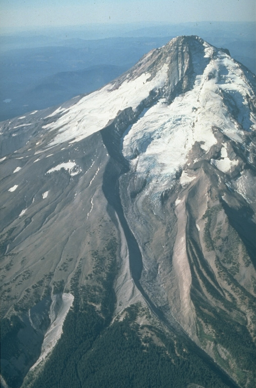 The north flank of Mount Hood contains the Eliot Glacier, with a series of prominent glacial moraines at its base in this 1987 photo. During the past 1,800 years eruptions have been restricted to vents on the SW flank and have included dome growth, collapse, and debris flows. Photo by Willie Scott, 1987 (U.S. Geological Survey).