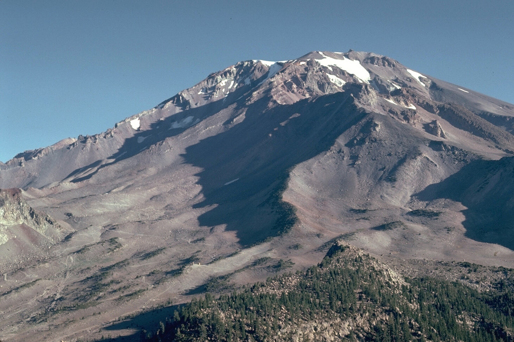 The extensively eroded Sargents Ridge (right of center), on the south side of Mount Shasta, is a remnant of the oldest of four major edifices that were constructed following the collapse of ancestral Mount Shasta. The Sargents Ridge cone formed during the Pleistocene, less than 250,000 years ago. Mount Misery was constructed less than 130,000 years ago and forms much of the upper part of the cone above the Sargents Ridge cone. Photo by Lee Siebert, 1981 (Smithsonian Institution).