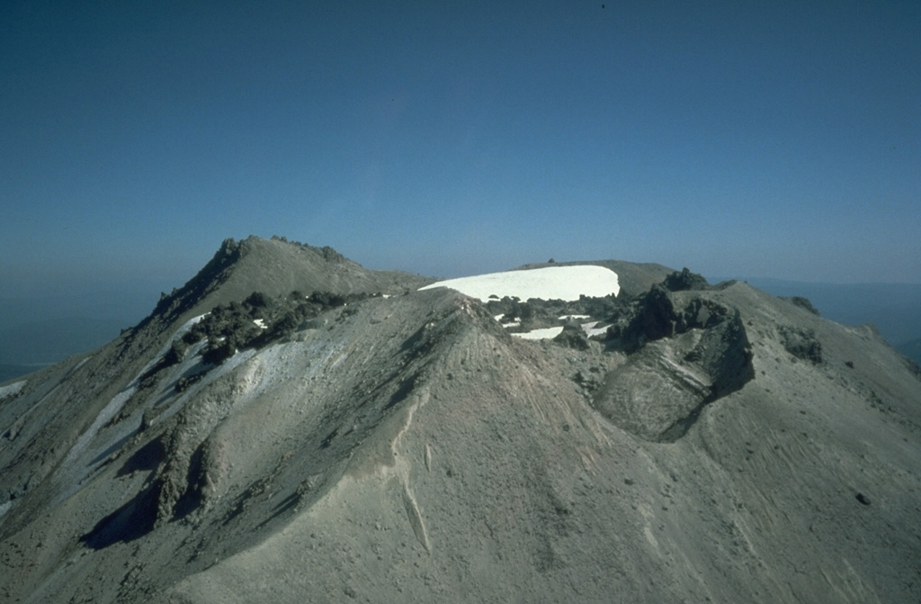 The summit of Lassen Peak contains a lava flow and several craters that formed during the 1914-1917 eruption. Lava flowed out of the crater through low points in the eastern and western crater rims. The NW crater in the foreground (right) formed during explosions near the end of the eruption in 1917.  Photo by Bill Chadwick, 1981 (U.S. Geological Survey).
