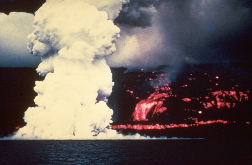A laze plume (hydrochloric acid, steam, and fine glass particles) rises from the west coast of the Island of Hawai’i on 2 June 1950 where a lava flow from Mauna Loa enters the sea. The Ka’apuna lava flow (right) was the last of three lobes that entered the sea on the second day of an eruption that originated high on the SW rift zone. The lava flow crossed the road encircling the island near Heku Point and destroyed a new restaurant and several buildings. The eruption lasted until 23 June. Photo by Gordon Macdonald (U.S. Geological Survey).