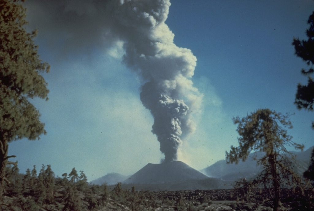 An ash plume rises from Parícutin in October 1944. The photo was taken from the north at the outskirts of the town of San Juan Parangaricutiro. Lava flows in the foreground had already buried the town; the church tower seen in many other photos of the Parícutin eruption is hidden behind the small tree to the right. Photo by Carl Fries, 1945 (U.S. Geological Survey, published in Luhr and Simkin, 1993).